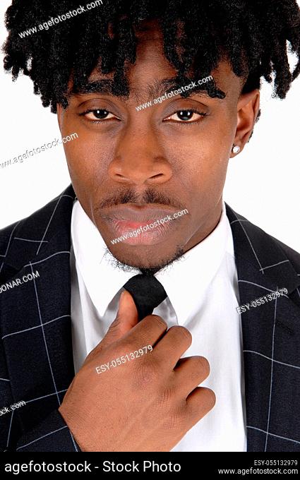 A close up image of an black man in a suit and white shirt and tie fixing his tie with fussy black hair, isolated for white background