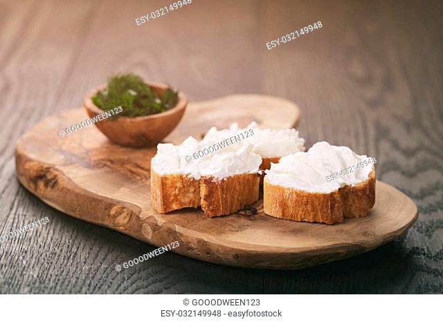 homemade appetizing crostini with soft cheese cream herbs, vintage toned