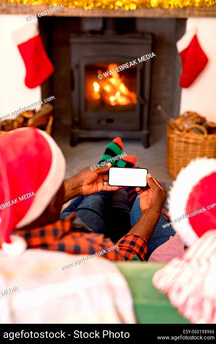 Back view of african american senior couple using smartphone with copy space at christmas time