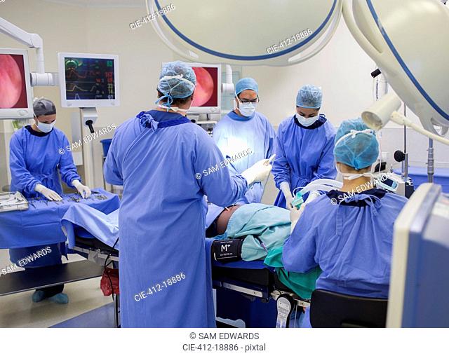 Team of doctors performing surgery in operating theater