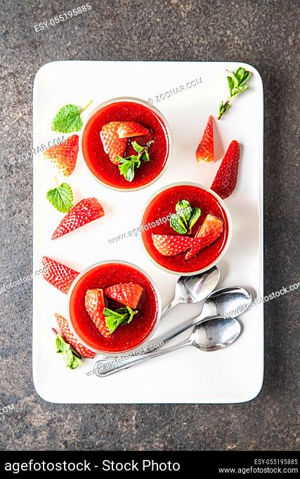 Italian dessert panna cotta with strawberries on white plate. Top view