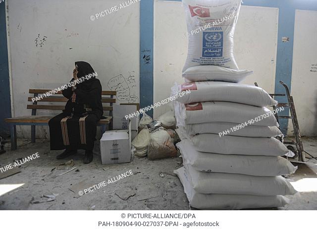 A Palestinian refugee woman waits to receive food aids provided by the United Nations Relief and Works Agency for Palestine Refugees (UNRWA) in Jabalia refugee...