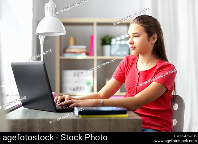 student girl with laptop computer learning at home