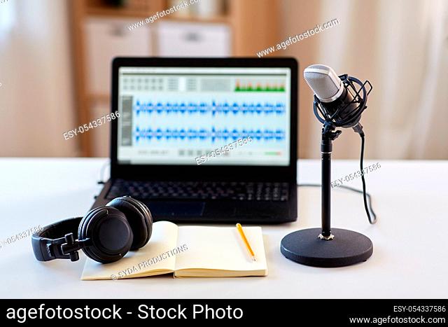 microphone, laptop, headphones, notebook on table