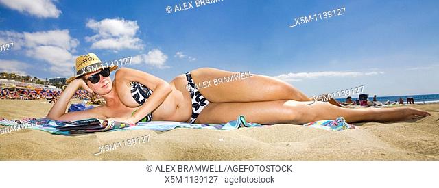 Woman lying on the beach in a panoramic viewpoint