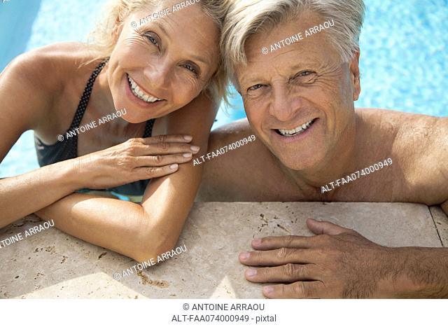 Mature couple relaxing together in pool, portrait
