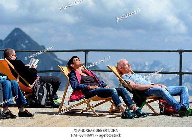 Visitors enjoy the sunshine on the observation terrace of Zugspitze mountain, Germany, 18 May 2015. Photo: Andreas Gebert/dpa | usage worldwide