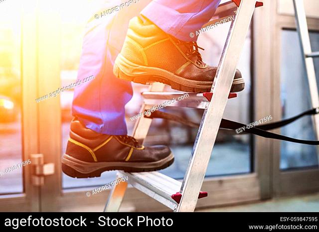 Low Section View Of A Handyman's Foot Climbing Ladder