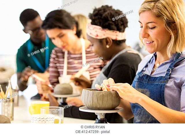Woman making clay bowl in art class