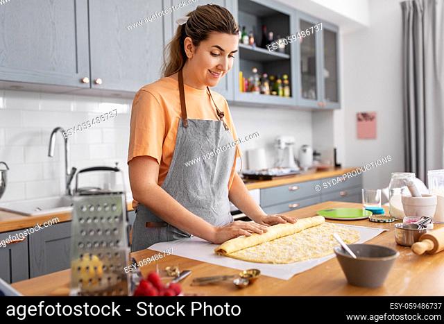 woman cooking food and baking buns at home kitchen