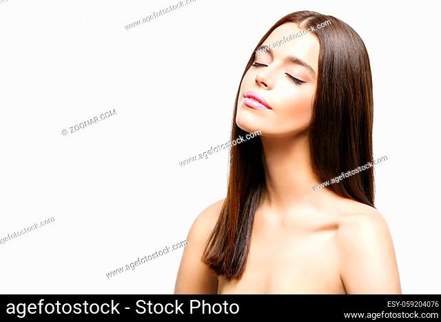 Beautiful young woman with healthy shiny straight hair and smooth skin. Beauty shot. Isolated over white background. Copy space