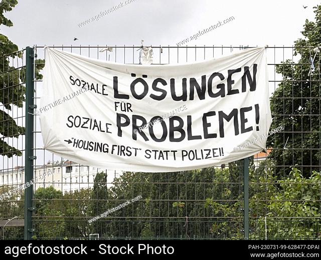 31 July 2023, Berlin: A banner hangs in Görlitzer Park. The green space in Kreuzberg is always a source of discussion. Only recently