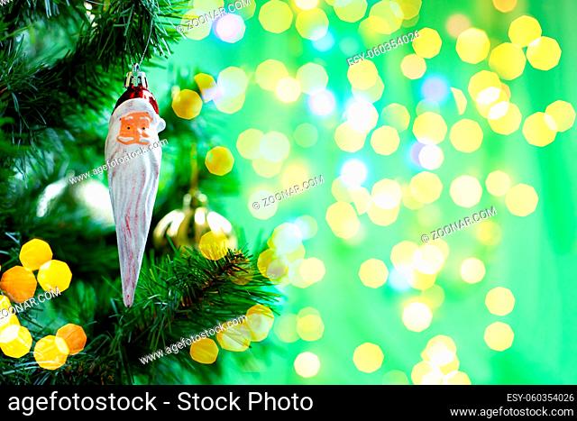 Christmas decoration santa claus with a long white beard on a branch of a christmas tree, christmas tree toy, background copy space sparkling shiny design for...