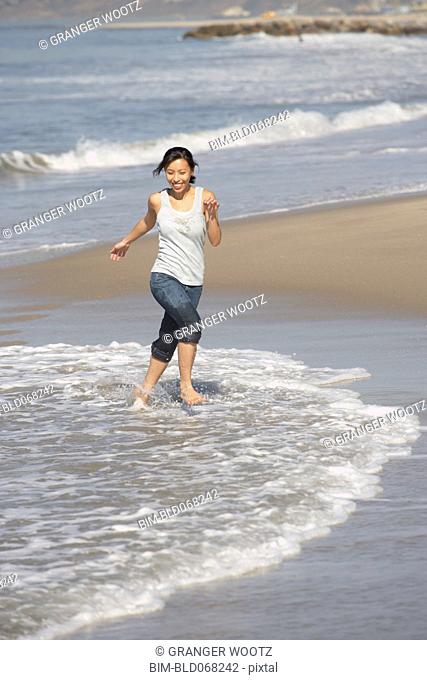 Asian woman wading at beach