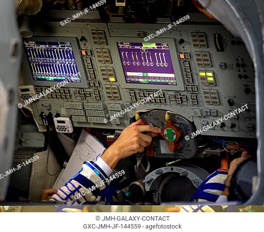 Expedition 52 flight engineer Randy Bresnik of NASA turns a dial inside the Soyuz simulator during his final Soyuz qualification exam with fellow Expedition 52...