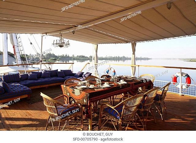 A coffee break on a covered sundeck on a boat with a view over the River Nile, Egypt