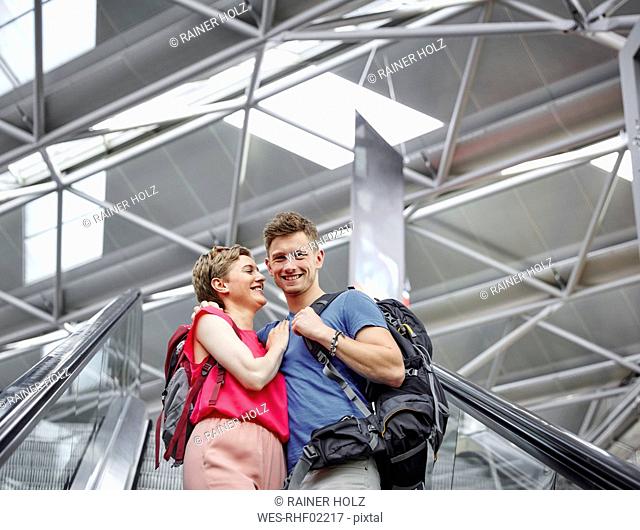 Happy couple on escalator at the airport