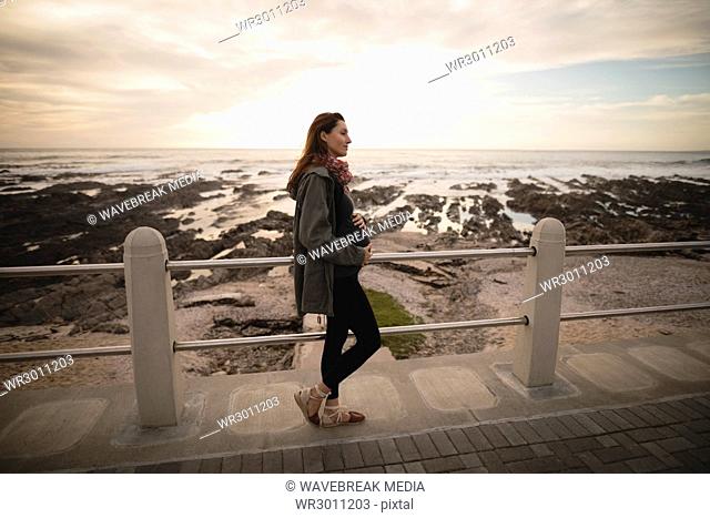 Pregnant woman standing near seaside