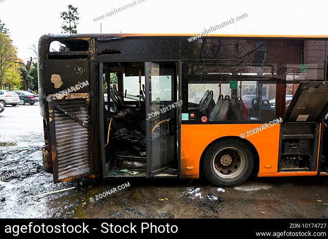 Burnt public traffic bus is seen on the street after caught in fire during travel and extinguished by firefighters