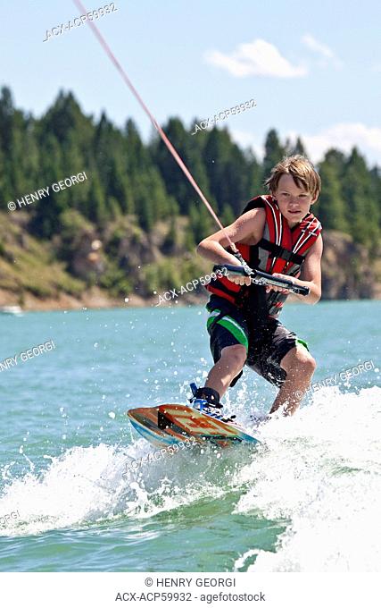 Young boy wakeboarding on Lake Koocanusa, East Kootenays, BC, Canada