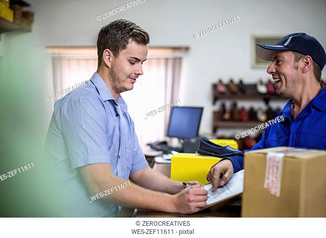 Man in warehouse signing on document for purchase
