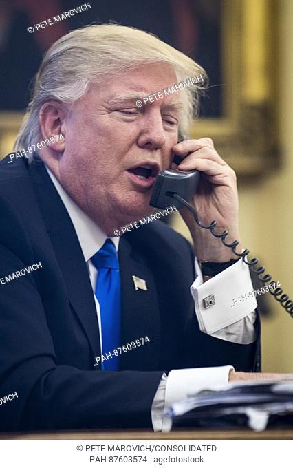 United States President Donald Trump speaks on the phone with Prime Minister of Australia, Malcolm Turnbull in the Oval Office on January 28, 2017 in Washington