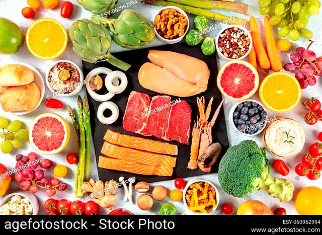 Various food products, shot from the top. Meat and fish, poultry, seafood, cheese, fruit, vegetables, nuts, legumes, mushrooms