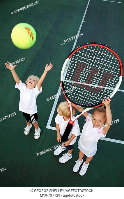 Kids playing with an oversized tennis racket and ball
