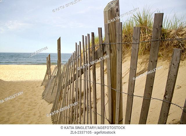 The Edge of a fence on a Sandy beach on the Cape cod shore in Cape Cod, Massachusset on a sunny day
