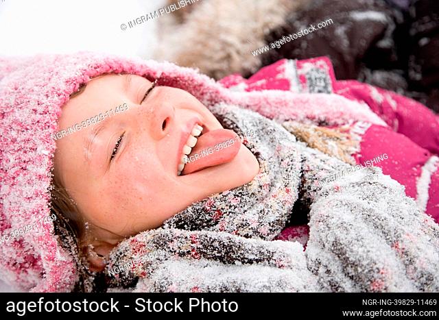 Girl in snow sticking out tongue