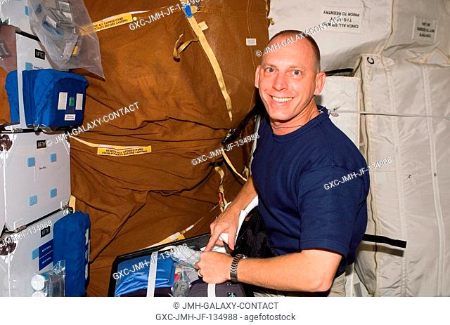 Astronaut Clayton Anderson, STS-117 mission specialist, works with stowage bags on the middeck of Space Shuttle Atlantis