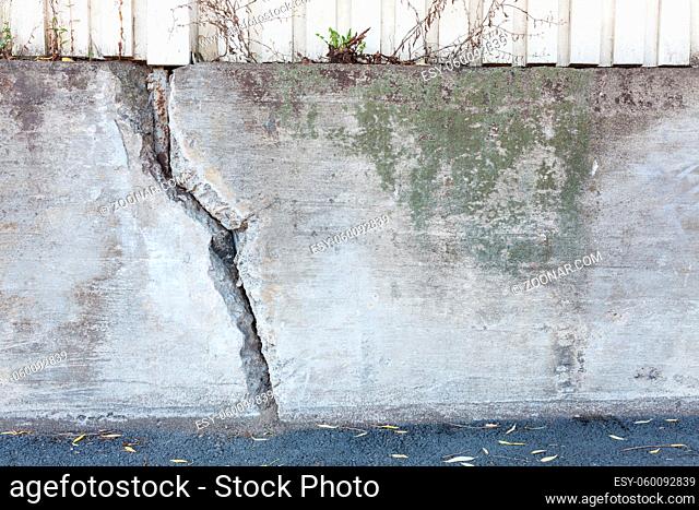 Big crack in messy outdoor concrete wall