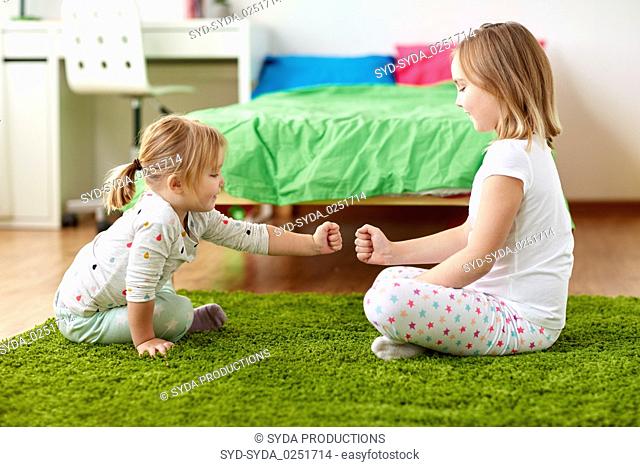 girls playing rock-paper-scissors game at home
