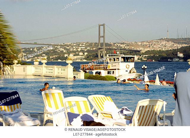 Swimming pool of the Ciragan Palace Hotel with Bosphorus bridge in background. Istanbul. Turkey