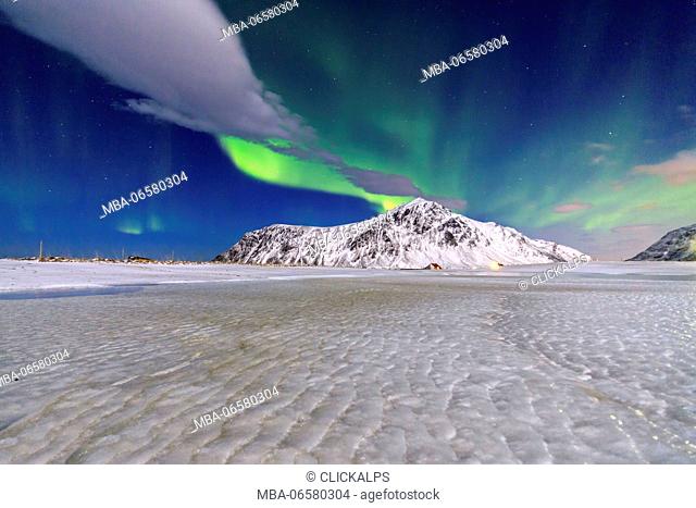 Northern Lights illuminate the sky and the snowy peaks, Flakstad, Lofoten Islands Northern Norway Europe