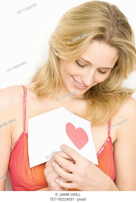 Woman holding card with heart