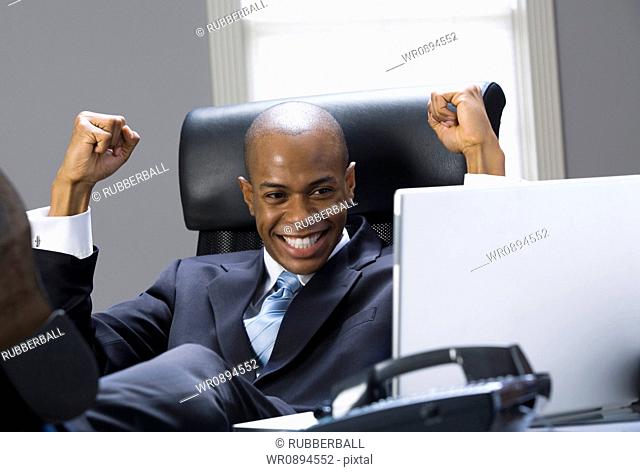 Close-up of a businessman smiling and clenching fists