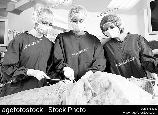 Surgery team operating in a surgical room