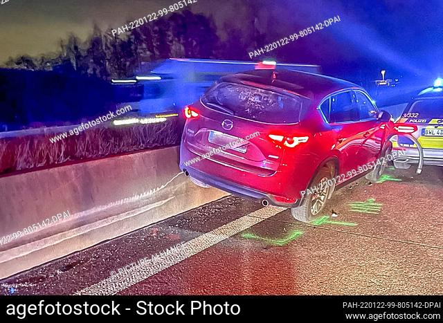 21 January 2022, Baden-Wuerttemberg, Offenburg: A car wedged by a patrol car stuck on the concrete center guardrail on the A5