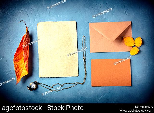 Autumn stationery mockup. Craft greeting cards or invitations with an envelope, overhead flat lay shot with fall leaves