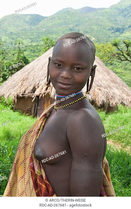 Young Surma woman, in front of village, Surma Tribe, Kibish, Omo River Valley, Ethiopia
