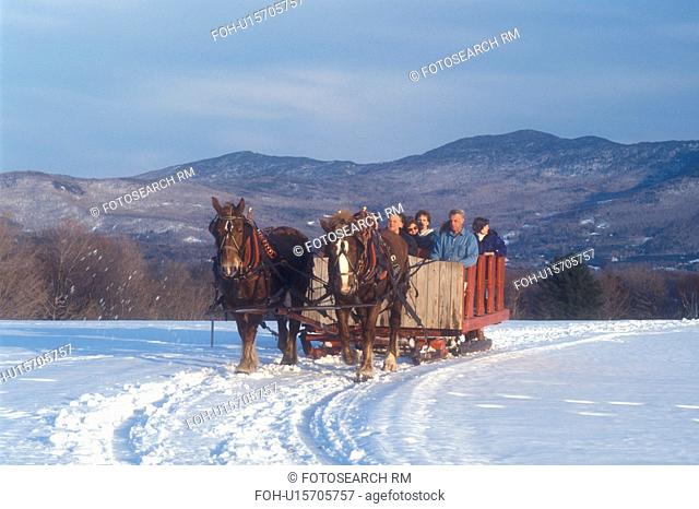 Stowe, sleigh ride, Vermont, VT, A team of horses pulls a red open sleigh full of people through the snow covered field at Trapp Family Lodge in Stowe