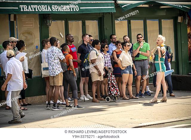 A tour group in Greenwich Village in New York stands in the shade to escape the heat on Saturday, July 20, 2019
