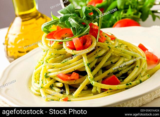 photo of delicious pasta with arugula pesto and cherry tomatoes