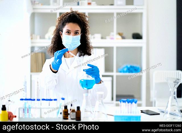 Female doctor testing chemical solution in hospital during COVID-19