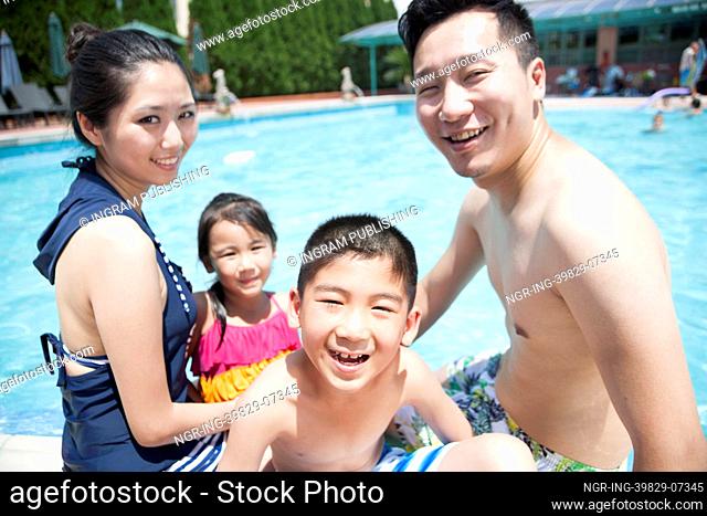 Cute little boy and his family playing in the pool