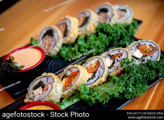 PRODUCTION - 07 November 2023, Lower Saxony, Oldenburg: Sushi with kale, tomatoes and feta (front) and sushi with kale and sausage on a table at the Moto...