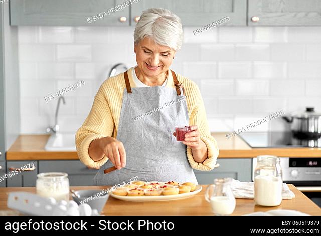 woman decorating cupcakes with berries on kitchen