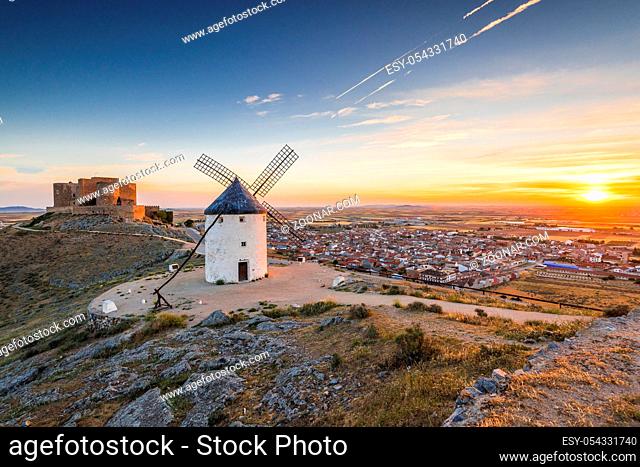 Sun rising over COnsuegra with legendary windmills and castle on hill top
