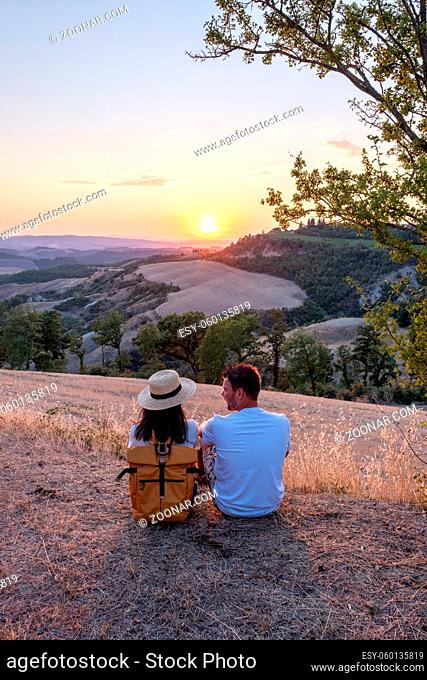 couple man and woman on vacation in Toscane Italy, man and woman mid age visiting Toscany region on the golden hills of Italy during a road trip